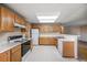 Functional kitchen with white appliances, ample wood cabinets, and neutral countertops at 11305 W Crestline Dr, Littleton, CO 80127