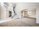 Bright and airy living room featuring soaring ceilings, carpeted floors, and a staircase with white railings at 11305 W Crestline Dr, Littleton, CO 80127
