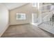 Bright living room with vaulted ceilings, neutral walls, large windows, and carpeted flooring at 11305 W Crestline Dr, Littleton, CO 80127