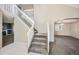 Open floor plan with staircase featuring white railings, carpeted stairs, and neutral paint colors at 11305 W Crestline Dr, Littleton, CO 80127