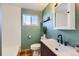 Updated bathroom with mint green walls and a modern vanity at 4330 Bruce Randolph Ave, Denver, CO 80207