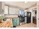 Kitchen features mint green cabinets, butcher block counters, and stainless steel appliances at 4330 Bruce Randolph Ave, Denver, CO 80207