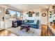 Bright living room with teal couch, wood floors, and entryway view at 4330 Bruce Randolph Ave, Denver, CO 80207