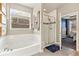Bathroom features a soaking tub, glass-enclosed shower and window with natural light at 599 Fall River Ct, Brighton, CO 80601