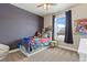 Bedroom featuring a colorful bed and a window with a view of the neighborhood at 599 Fall River Ct, Brighton, CO 80601