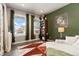 Green living room features hardwood floors, a window and a bookcase at 599 Fall River Ct, Brighton, CO 80601