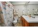 Comfortable bathroom featuring dual sinks, seashell shower curtain, and warm, bright decor at 3303 Blue Grass Cir, Castle Rock, CO 80109
