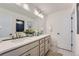 Bright bathroom featuring double sinks, white cabinets, quartz countertops, and modern fixtures at 6880 Bryant Way, Denver, CO 80221
