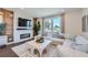 Bright living room with a fireplace, mounted tv, large picture window, and comfortable white seating at 6880 Bryant Way, Denver, CO 80221
