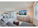 Modern living room featuring a comfortable sofa, a custom entertainment center and access to a balcony at 6880 Bryant Way, Denver, CO 80221