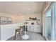 Stylish wet bar with white cabinets, bar stools, beverage cooler, floating shelves, and wine storage at 6880 Bryant Way, Denver, CO 80221
