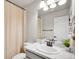 Bright bathroom with white marble countertops, neutral tones, and a bathtub with shower, exuding elegance at 7012 S Undergrove Way, Aurora, CO 80016