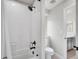 Modern bathroom featuring a bathtub with white tiled walls, a shower, and a sleek toilet for a clean aesthetic at 7012 S Undergrove Way, Aurora, CO 80016