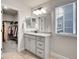 Bathroom featuring a granite countertop vanity, a large mirror and access to a walk-in closet at 7012 S Undergrove Way, Aurora, CO 80016