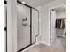 Modern bathroom featuring a glass enclosed shower with black trim and access to a walk-in closet at 7012 S Undergrove Way, Aurora, CO 80016