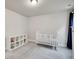 Bright Bedroom with a white crib, soft gray carpet and white shelving unit for toys and books at 7012 S Undergrove Way, Aurora, CO 80016