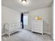 Charming Bedroom with a white crib, dresser, and soft lighting for a peaceful and comforting environment at 7012 S Undergrove Way, Aurora, CO 80016
