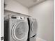 Functional laundry area featuring modern front load washer and dryer and shelving for storage at 7012 S Undergrove Way, Aurora, CO 80016