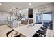 Open concept living space with kitchen, dining room, and staircase with a view of the fireplace and outdoor patio at 7012 S Undergrove Way, Aurora, CO 80016