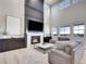 Stunning living room featuring a cozy fireplace, elegant decor, and large windows providing plenty of natural light at 7012 S Undergrove Way, Aurora, CO 80016