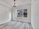 Bright, empty room with hardwood floors, base molding, and a large window at 1304 Snowberry # 204, Louisville, CO 80027