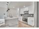 Modern kitchen boasts an island with quartz countertops, stainless steel appliances, and ample cabinet space at 1304 Snowberry # 204, Louisville, CO 80027