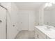 Bright bathroom with tiled floor, single sink vanity, and glass-enclosed shower with multiple storage options at 8374 E 132Nd Pl, Thornton, CO 80602