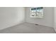 Bedroom featuring bright walls, neutral carpet, and a large window at 8374 E 132Nd Pl, Thornton, CO 80602