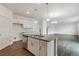 Well-lit kitchen features white cabinetry, stainless steel appliances, and a center island with sink at 8374 E 132Nd Pl, Thornton, CO 80602
