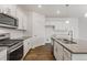 Bright kitchen boasts stainless steel appliances, white cabinets, and an island with a sink at 8374 E 132Nd Pl, Thornton, CO 80602