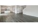 Spacious living room showcasing wood floors flowing into a kitchen with white cabinets and stainless appliances at 8374 E 132Nd Pl, Thornton, CO 80602