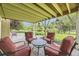 Enjoy a covered patio with red chair seating and views of the landscaped backyard at 5475 W Ottawa Ave, Littleton, CO 80128