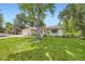Lovely home exterior featuring a lush green lawn and a large shade tree at 5475 W Ottawa Ave, Littleton, CO 80128