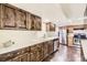 Well-lit kitchen featuring stainless steel appliances, wooden cabinets, and tiled floors at 5475 W Ottawa Ave, Littleton, CO 80128