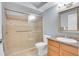 Bathroom featuring walk in shower with glass door, light wood vanity, and light tile work at 710 S Clinton St # 6A, Denver, CO 80247