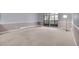 Living room featuring neutral walls, beige carpet, and access to the balcony at 710 S Clinton St # 6A, Denver, CO 80247