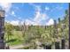 Scenic view of the golf course from a balcony shows lush green grass, tall trees, and blue skies with white clouds at 14001 E Marina Dr # 606, Aurora, CO 80014