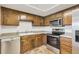 Classic kitchen featuring wood cabinets, laminate counters, stainless steel appliances, and tiled floors, enhancing functionality at 14001 E Marina Dr # 606, Aurora, CO 80014