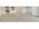 Open concept living room shows the entryway and the kitchen, and it is filled with neutral colored carpet and paint at 14001 E Marina Dr # 606, Aurora, CO 80014