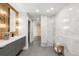 Elegant bathroom with marble-tiled shower, double vanity and modern fixtures at 333 S Monroe St # 211, Denver, CO 80209