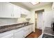 Kitchen featuring white cabinets, white appliances, and wood-look flooring at 17505 E Mansfield Ave # 1411L, Aurora, CO 80013