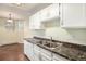 Close up of the kitchen sink with black and brown marble patterned counters and white subway tile at 17505 E Mansfield Ave # 1411L, Aurora, CO 80013