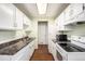 Galley kitchen featuring white cabinets, white appliances, and wood-look flooring at 17505 E Mansfield Ave # 1411L, Aurora, CO 80013