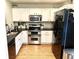 This kitchen has stainless steel appliances, black countertops, white cabinets and wood floors at 1286 Finch Ave, Brighton, CO 80601