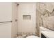 Bathroom with marble accent wall, rainfall shower head and built-in shower niche at 1330 E 90Th Ave, Thornton, CO 80229