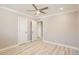 Neutral bedroom with wood-look floors, ceiling fan and three doors at 1330 E 90Th Ave, Thornton, CO 80229