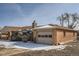 View of the home's detached garage with brick exterior and snow on the roof at 1330 E 90Th Ave, Thornton, CO 80229