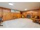 Large finished basement with wood paneling and a traditional brick fireplace at 8840 Niwot Rd, Niwot, CO 80503