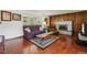 Cozy living room with a brick fireplace, wood-paneled accent wall, and hardwood floors at 8840 Niwot Rd, Niwot, CO 80503