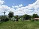Large lot featuring mature trees, grassy areas, sheds, and distant mountain views under a partly cloudy sky at 8840 Niwot Rd, Niwot, CO 80503